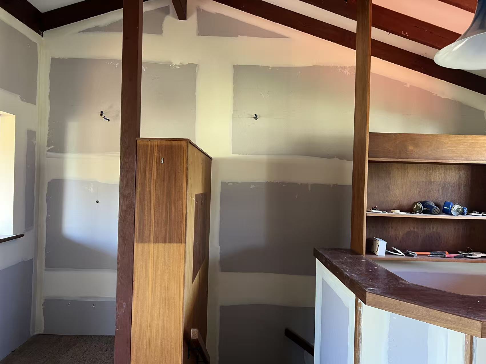 Double-height void with exposed timber beams and plasterboard ceiling